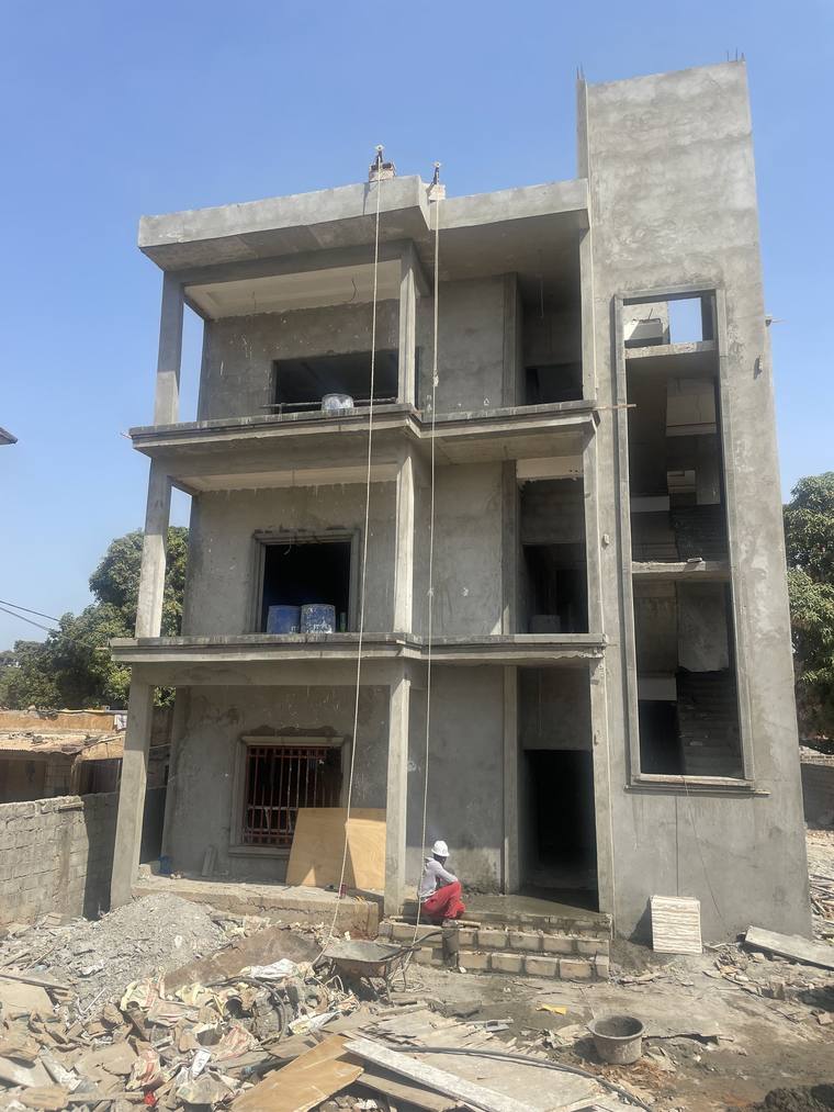 The front of the structure before rendering, showing the cast concrete frame, the floor slabs and the projecting balconies.
