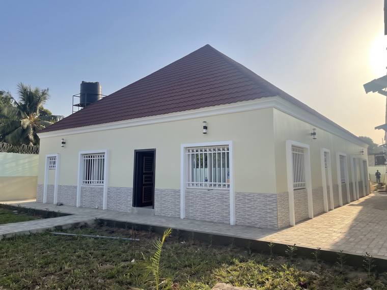 The corner of the completed house, showing the length of the side elevation and the paving laid alongside it.