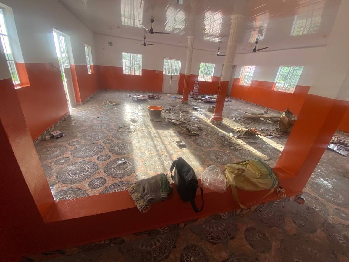 The prayer hall with the walls painted and the patterned floor tiling complete, the room still to be cleared.