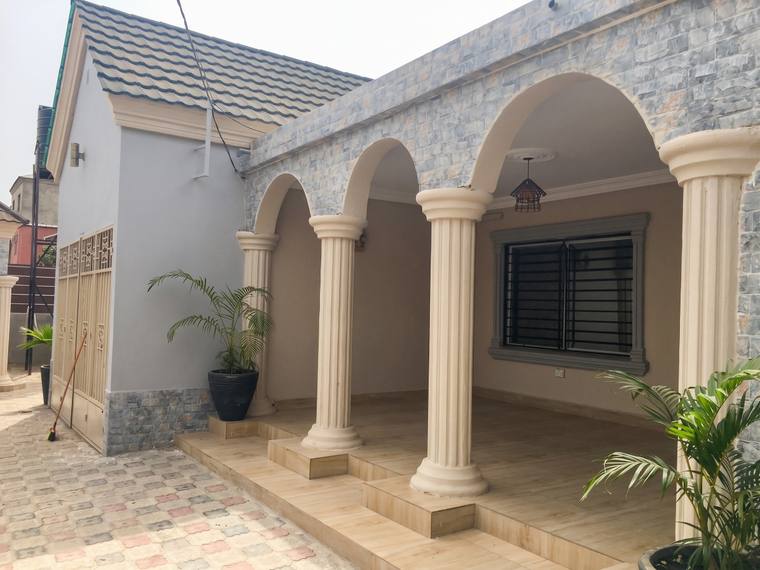 The arcaded veranda along the front of the villa, its rendered arches carried on fluted columns above a tiled floor.